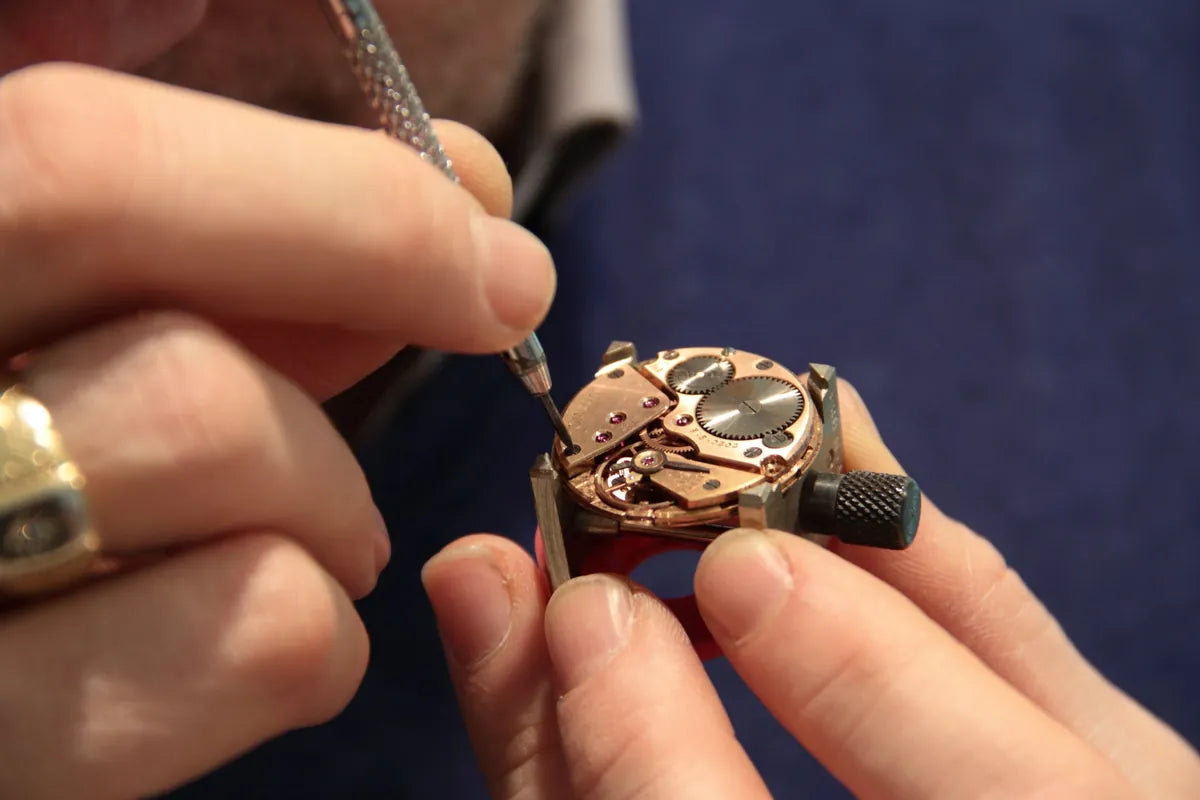 Jeweler using a small screwdriver to open the back of a watch